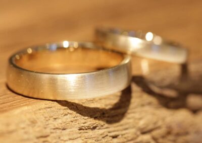 individeulle eheringe mit zwei herzhälften aufgesetzt und brillant