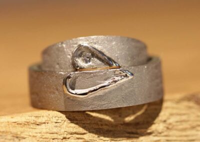 individeulle eheringe mit zwei herzhälften aufgesetzt und brillant