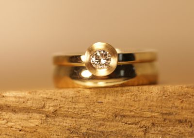 Gold Solitaer Ring neben Trauring Schmuckgarten
