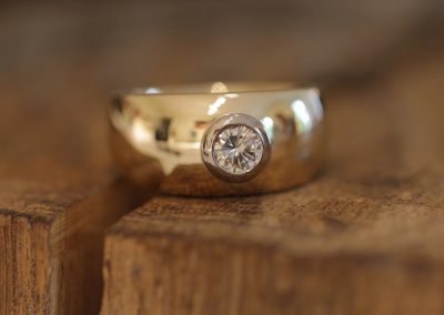 breiter schmuck ring aus gelbgold mit brillant in weißgold fassung