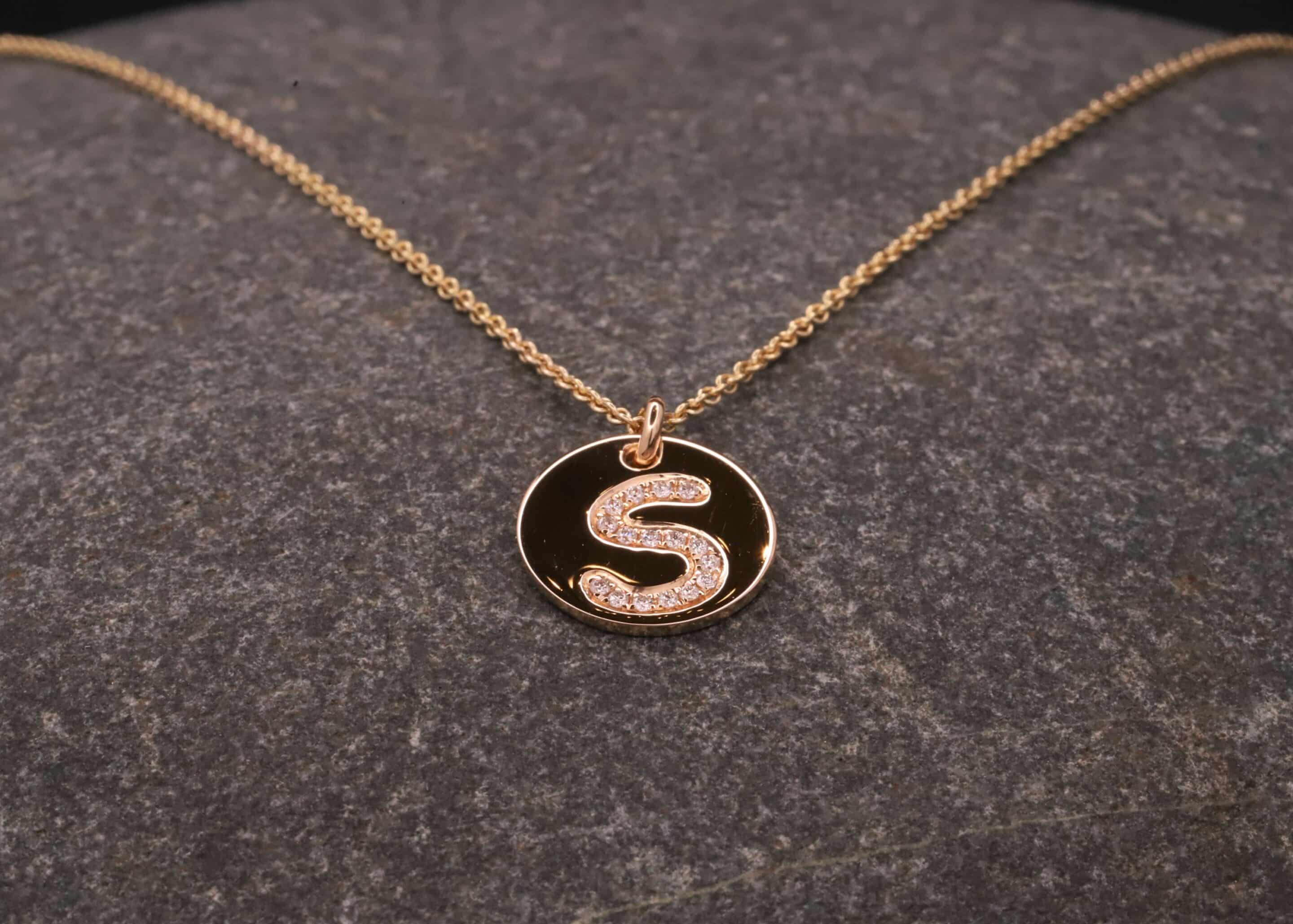 runder gold anhänger mit einem s aus brillanten schmuckgarten stolberg
