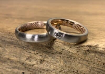Ein Paar Trauringe aus 585er Graugold und Rotgold Steckloetringe Damenring mit Baguette Diamant und Lasergravur
