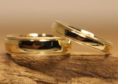 Besondere Eheringe mit Millgriffrand aus 585er Gelbgold Oberflaeche poliert