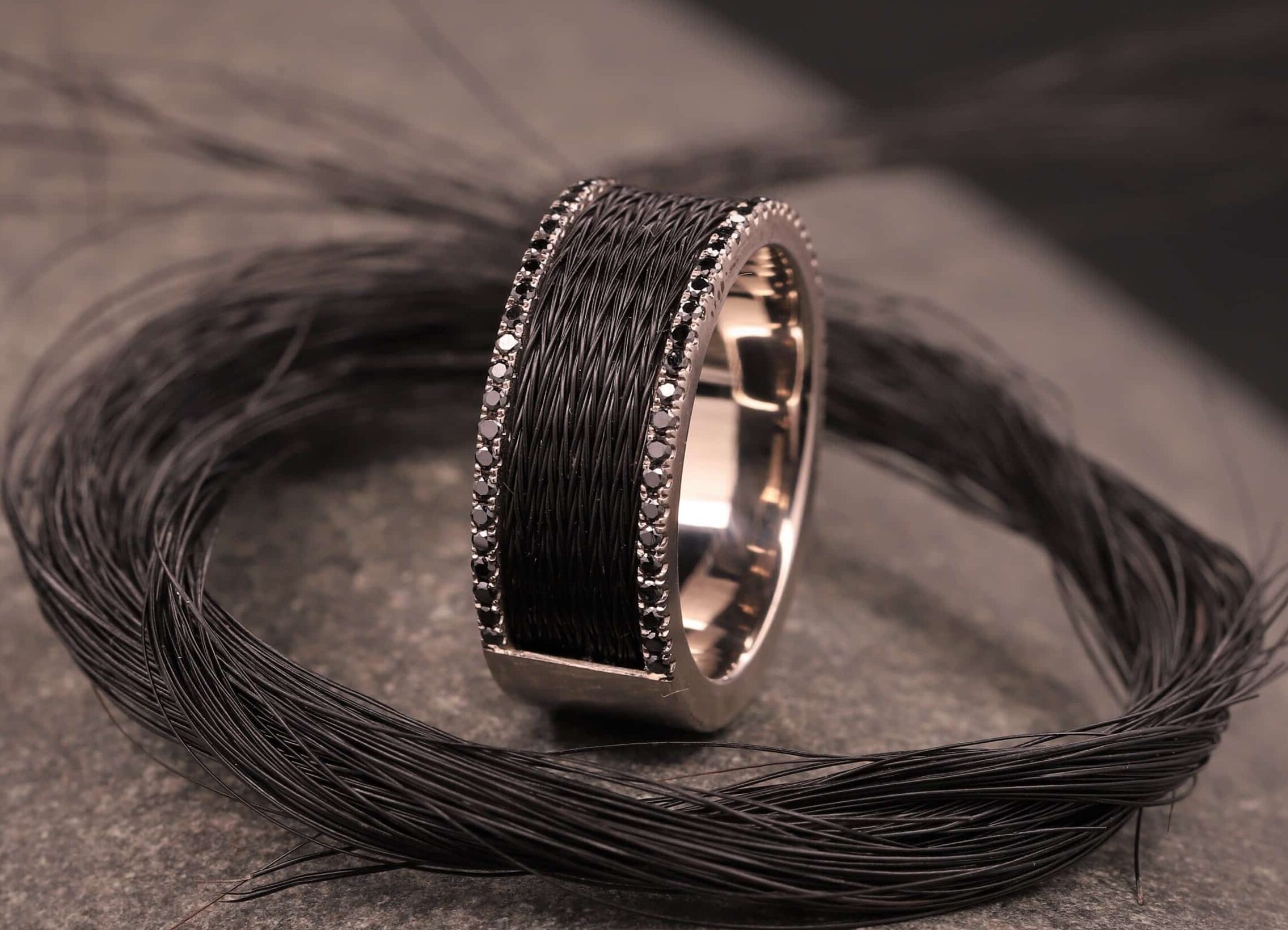 grau gold ring mit schwarzen brillanten und schwarzen pferdehaaren