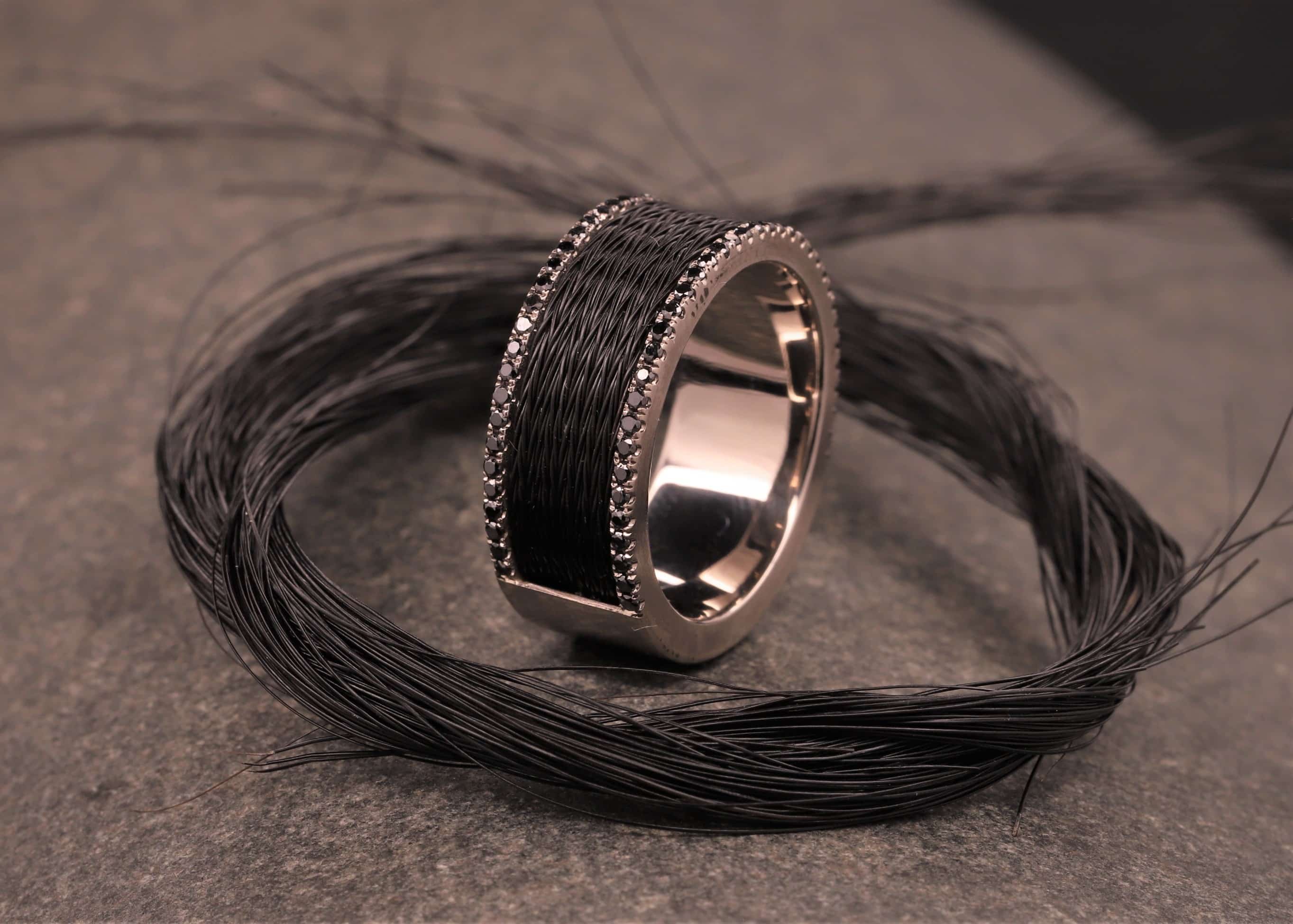 grau gold ring mit schwarzen brillanten und schwarzen pferdehaaren
