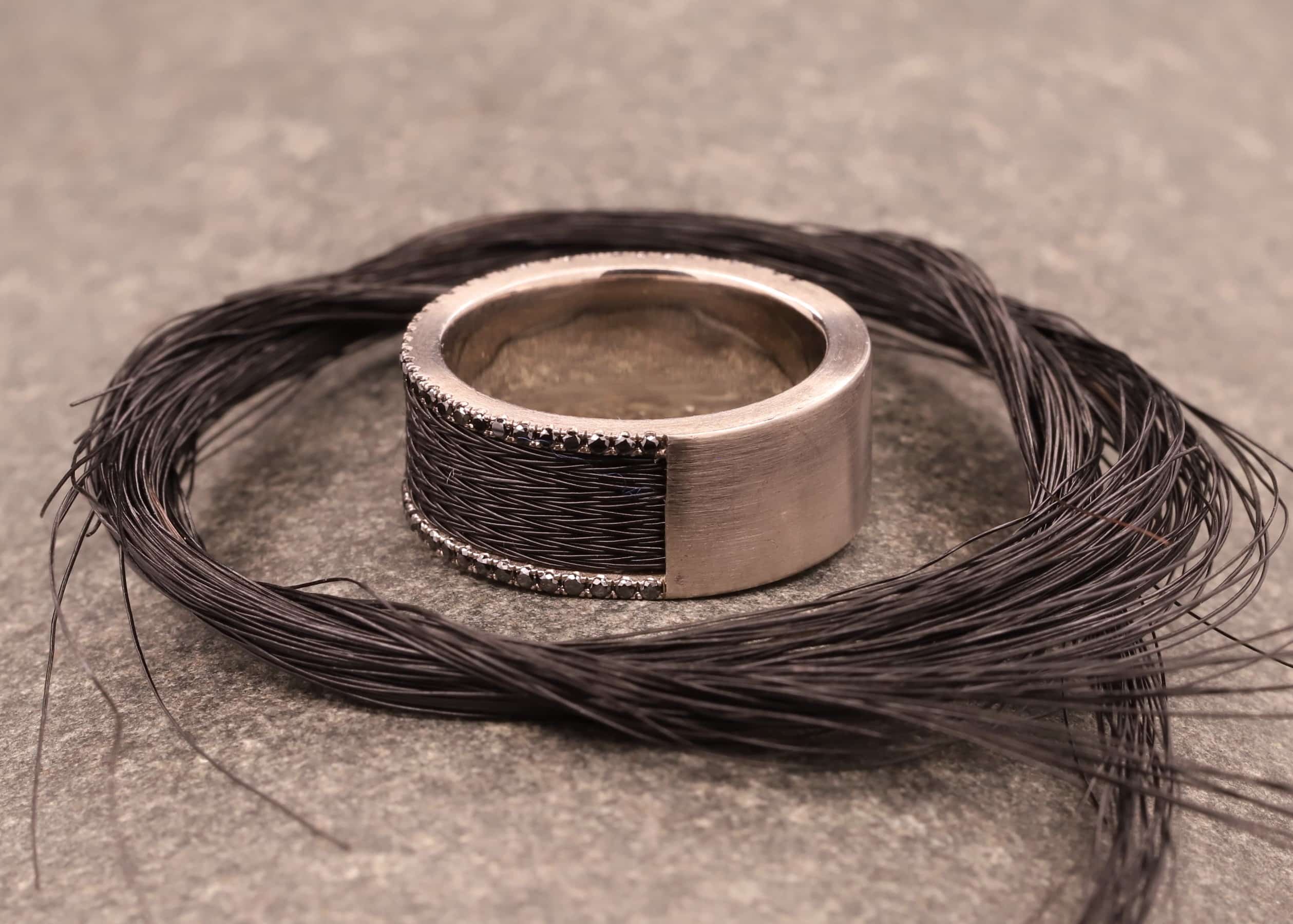 grau gold ring mit schwarzen brillanten und schwarzen pferdehaaren