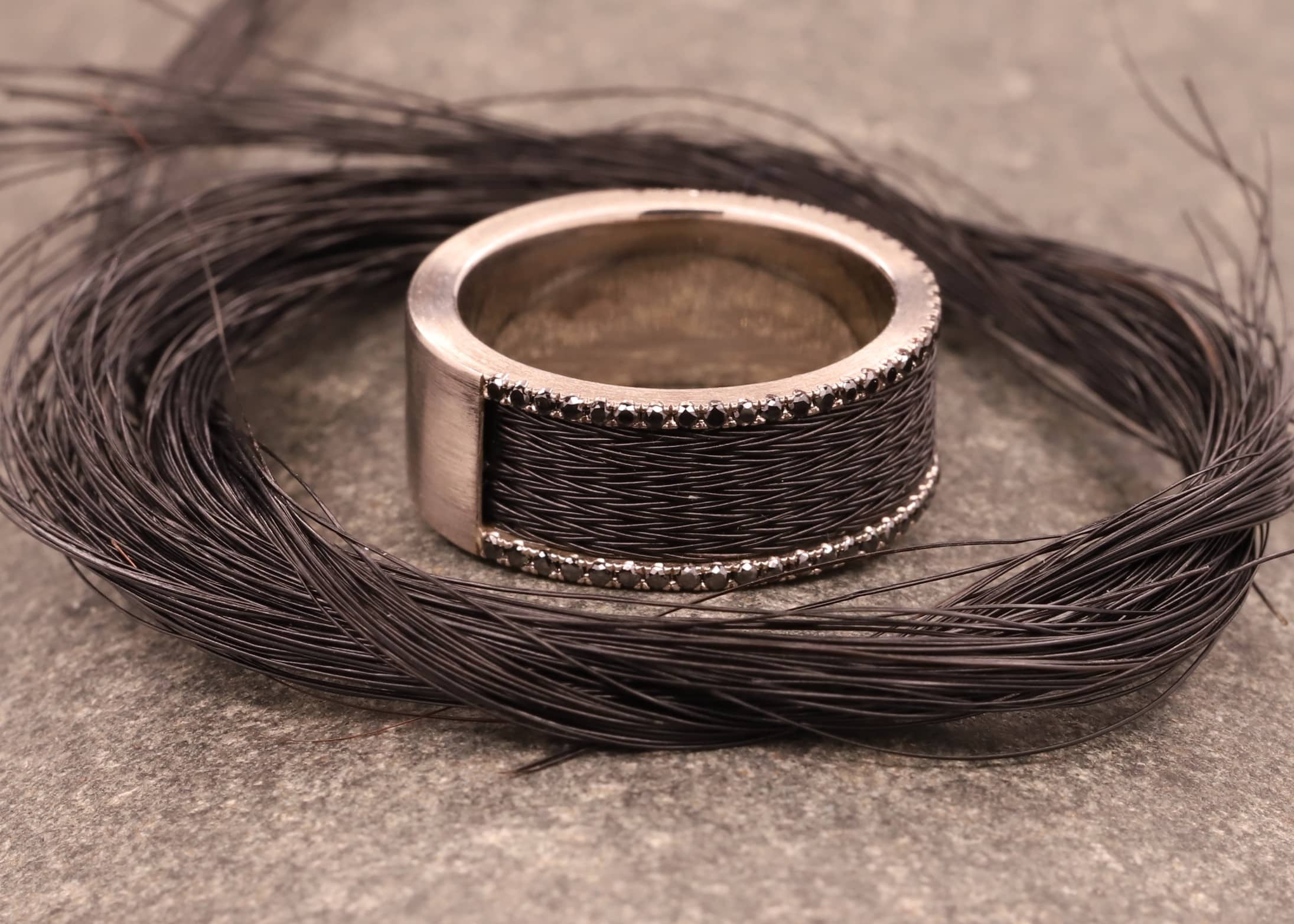 grau gold ring mit schwarzen brillanten und schwarzen pferdehaaren