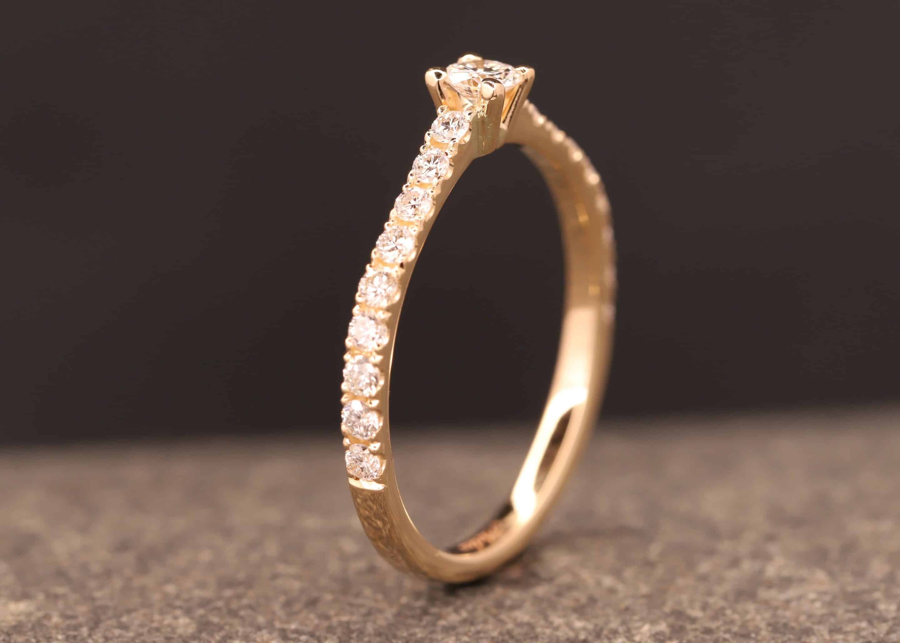 verlobungsring in rose gold mit großen diamant und kleinen diamanten in der ringschiene