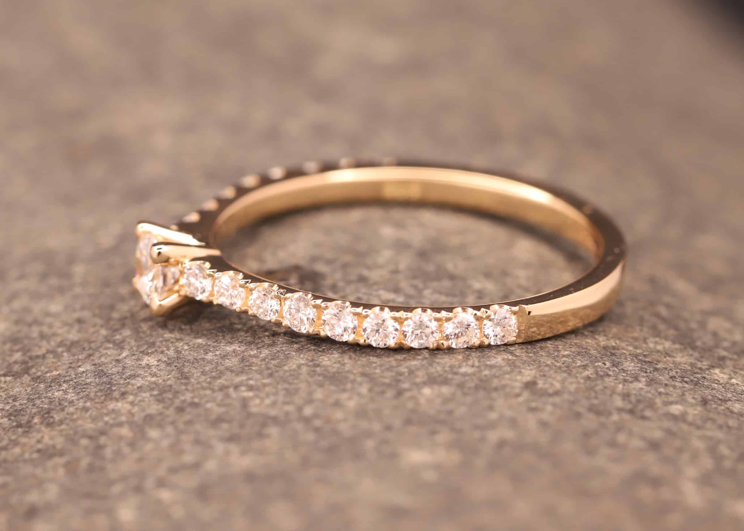 verlobungsring in rose gold mit großen diamant und kleinen diamanten in der ringschiene