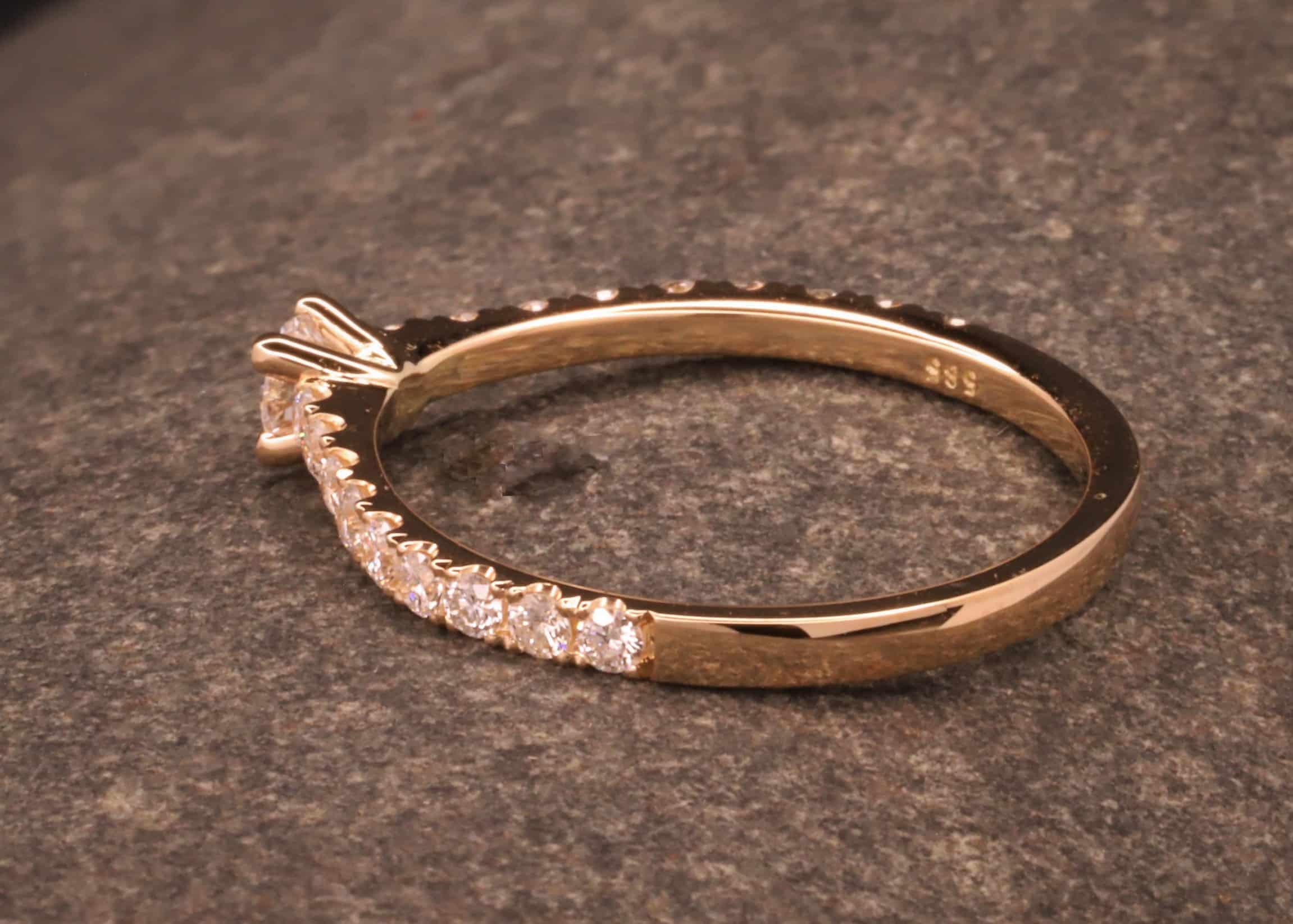 verlobungsring in rose gold mit großen diamant und kleinen diamanten in der ringschiene