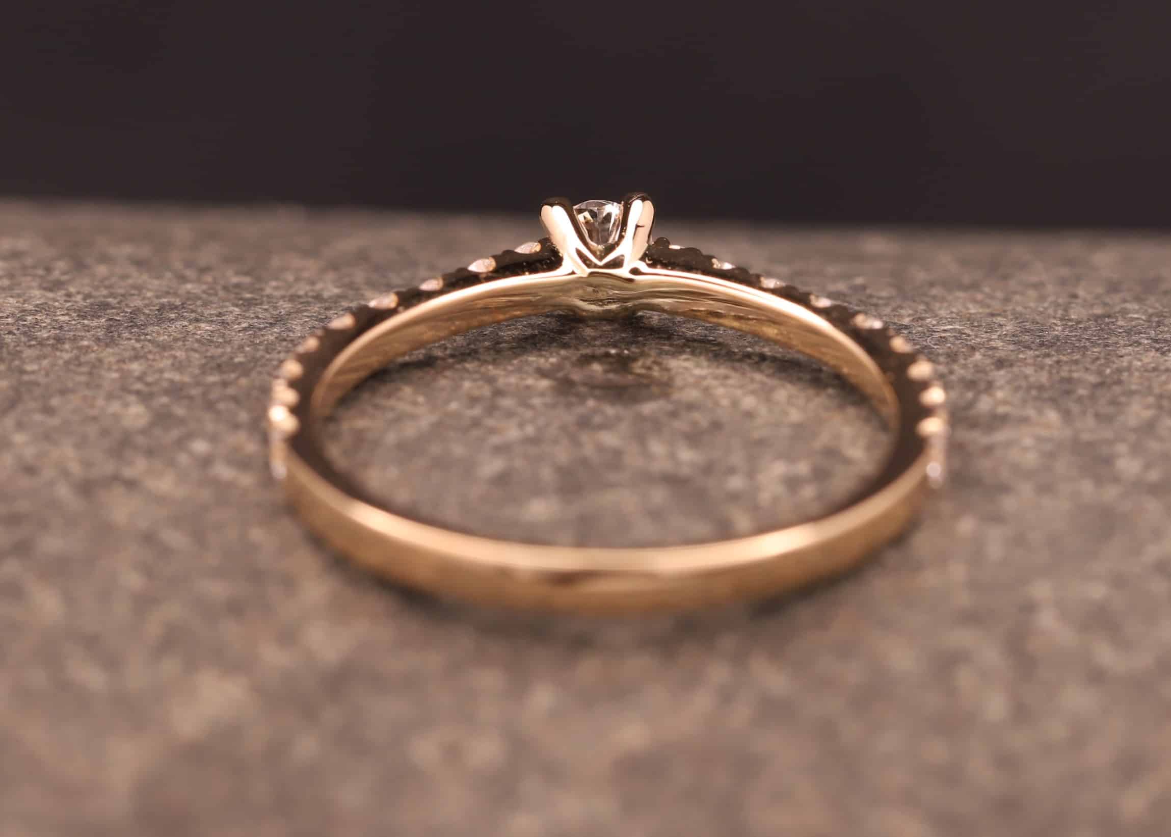 verlobungsring in rose gold mit großen diamant und kleinen diamanten in der ringschiene