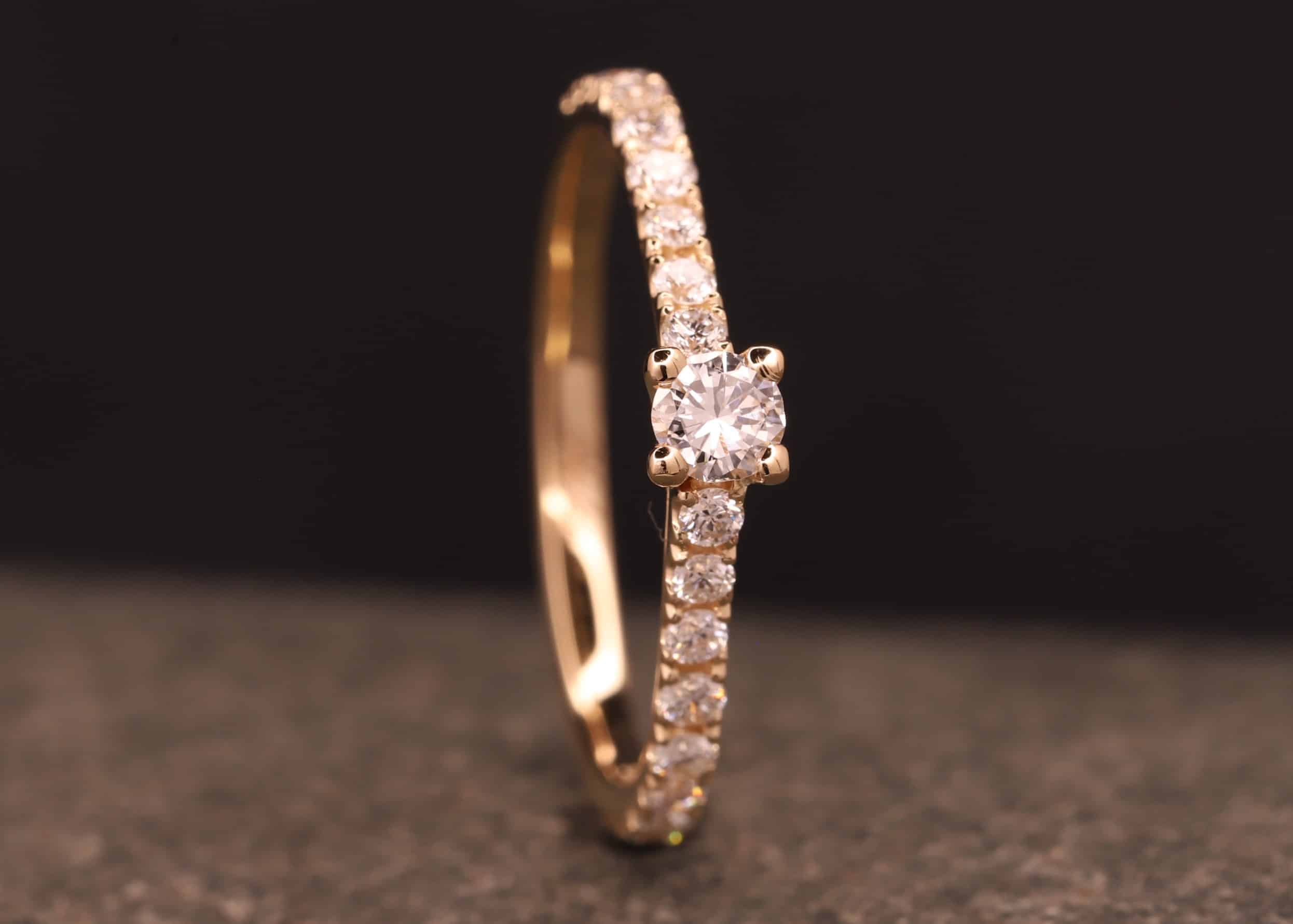 verlobungsring in rose gold mit großen diamant und kleinen diamanten in der ringschiene