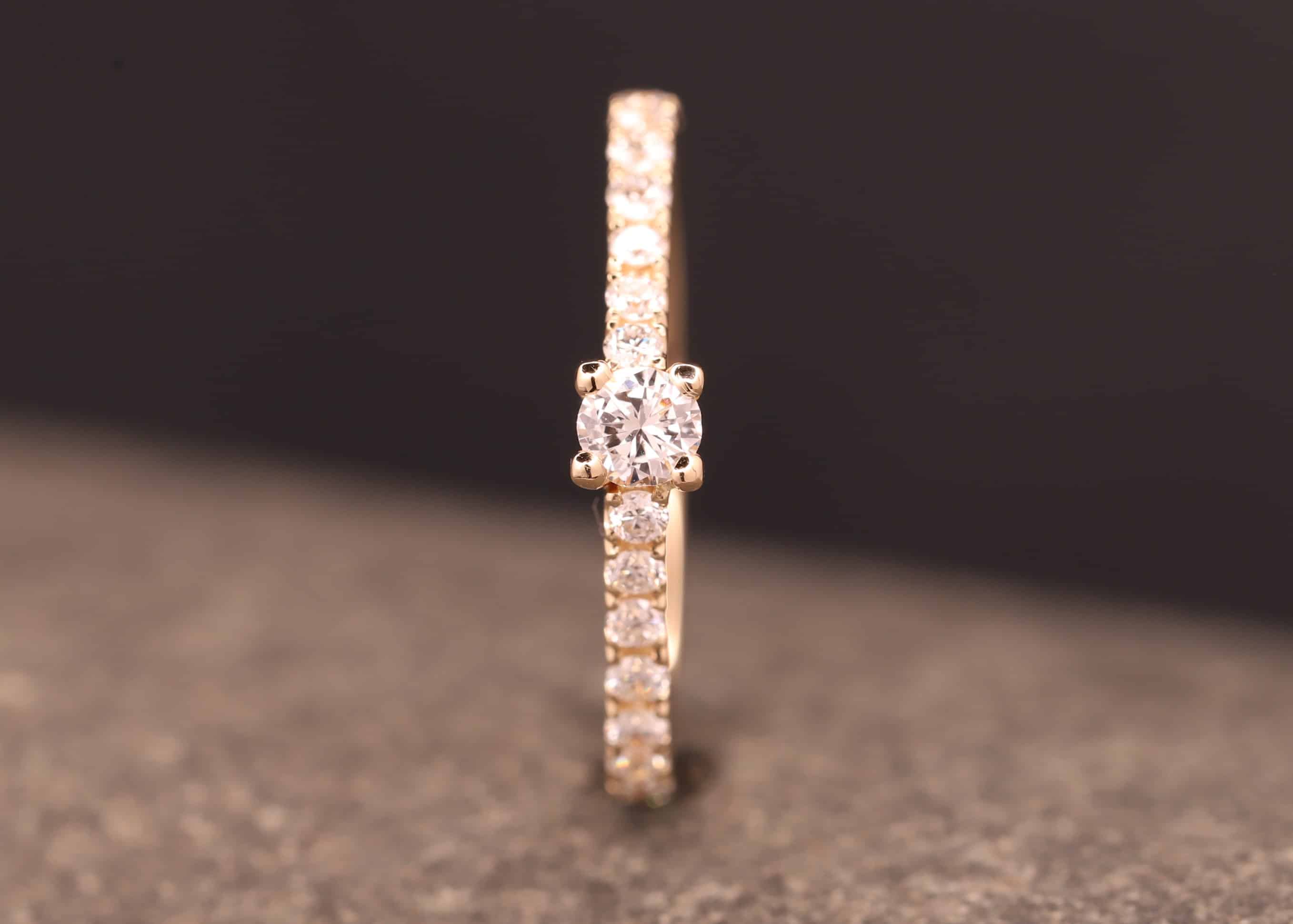 verlobungsring in rose gold mit großen diamant und kleinen diamanten in der ringschiene